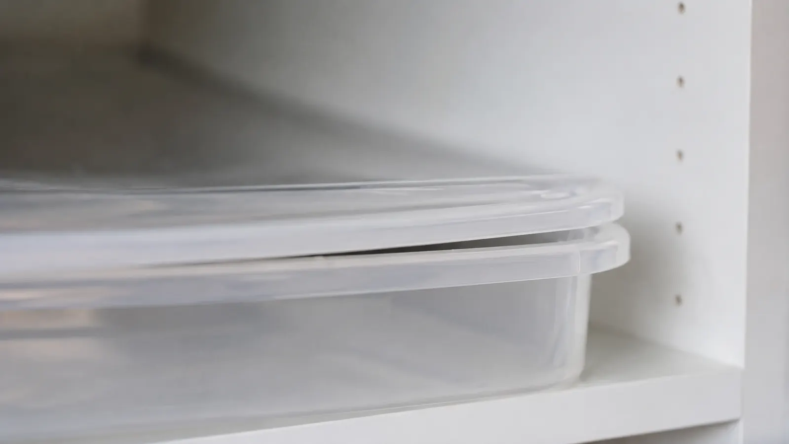 Close-up of a slightly warped plastic lid on a clear storage bin that no longer clicks fully flush